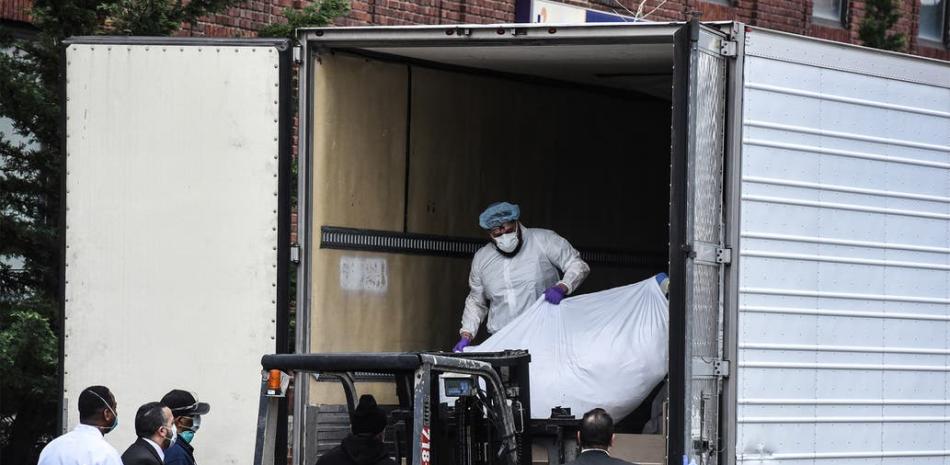 En plena crisis por el avance del coronavirus, los trabajadores sanitarios llevan un cuerpo a un camión refrigerado afuera del Hospital de Brooklyn / AFP - Crédito: Stephanie Keith