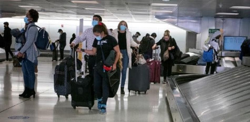 Viajeros recogen su equipaje en el Aeropuerto Internacional de Newark en Nueva Jersey. Foto: Kena Betancur/AFP.