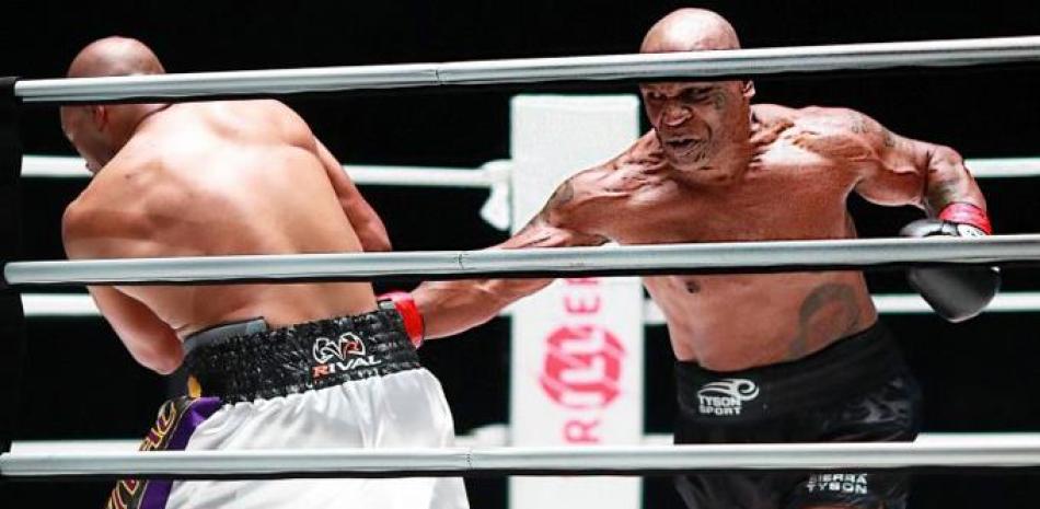El extitular pesado Mike Tyson castiga a Roy Jones Jr. con un golpe al cuerpo durante un pleito este sabado. (AP)