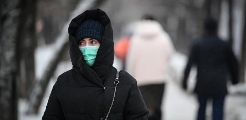 Una mujer con mascarilla camina por un bulevar en el centro de Moscú el 1 de diciembre de 2020, en medio de la crisis relacionada con la pandemia Covid-19 causada por el nuevo coronavirus.