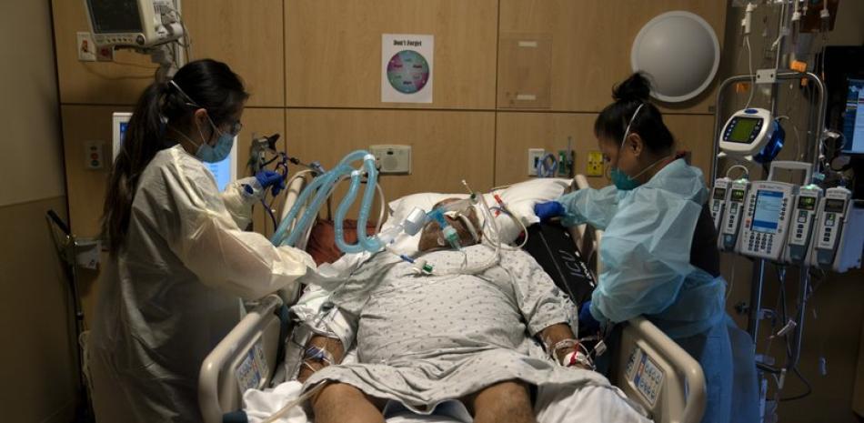 En esta fotografía de archivo del 19 de noviembre de 2020, las enfermeras Karen Ross (derecha) y Angela Nguyen atienden a un paciente enfermo de COVID-19 en el Centro Médico Providence Holy Cross, en el sector Mission Hills de Los Ángeles. (AP Foto/Jae C. Hong, Archivo)