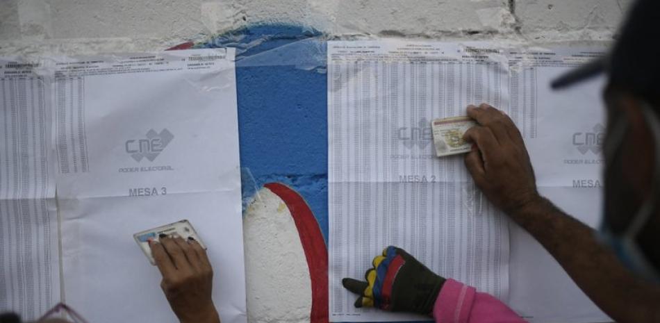Votantes comprueban dónde deben votar en las elecciones a la Asamblea Nacional en Caracas, Venezuela, el domingo 6 de diciembre de 2020. Los comicios fueron rechazados por los líderes opositores más influyentes, que los tacharon de fraude. (AP Foto/Matias Delacroix)