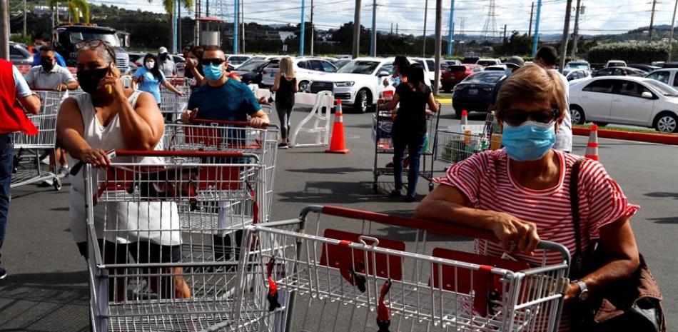Clientes esperan para entrar a un supermercado a abastecerse el 3 de diciembre de 2020 en San Juan (Puerto Rico). EFE/Thais Llorca