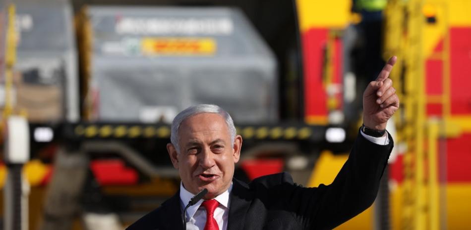 El primer ministro israelí, Benjamin Netanyahu, hace un gesto durante una ceremonia para conmemorar la llegada de un avión de la empresa de mensajería internacional DHL, que transportaba más de 100.000 dosis del primer lote de vacunas Pfizer.