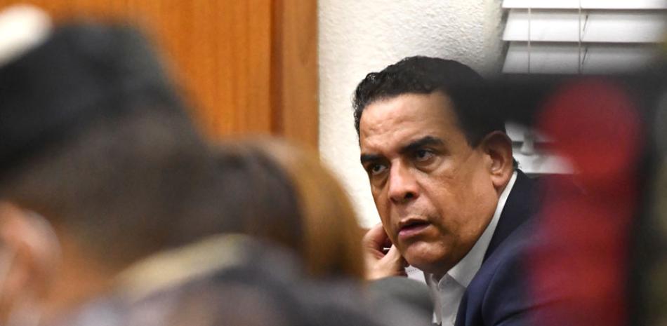 Alexis Medina Sánchez, hermano del expresidente Danilo Medina, escucha atento al juez José Alejandro Vargas, quien le impuso anoche tres meses de prisión preventiva como medida de coerción por presuntos actos de corrupción, al igual que a otros seis implicados en el llamado caso Anti-Pulpo.