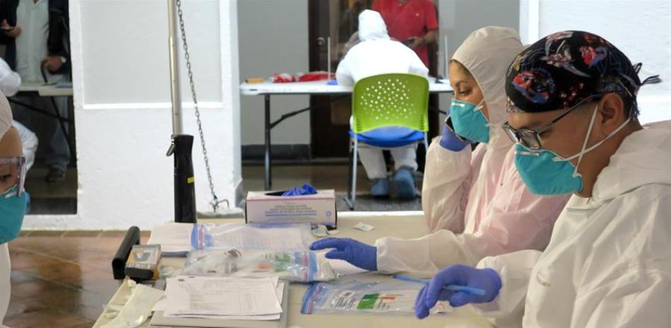 Unos técnicos de laboratorio empaquetan en bolsas de plástico las pruebas del coronavirus realizadas, el 24 de junio del 2020, en San Juan (Puerto Rico). EFE/Jorge Muñiz/Archivo