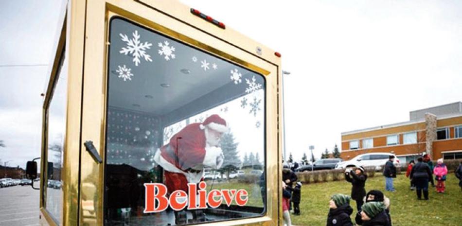 Santa Claus saluda a niños en Ontario. AP