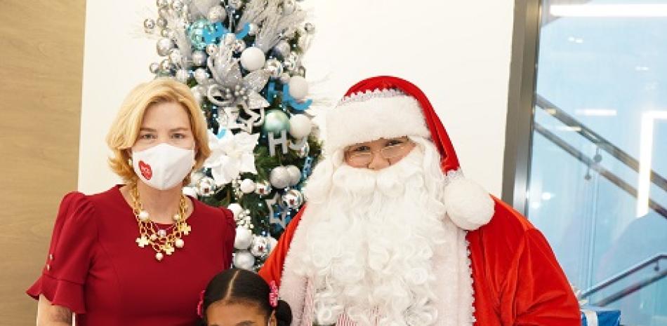 Susana Caro y una niña de Heart Care junto a Santa Claus.