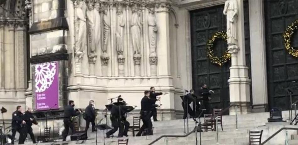 Agentes de la policía de Nueva York se mueven en la escena de un tiroteo en la Catedral de San Juan el Divino, el domingo 13 de diciembre de 2020, en Nueva York. (AP Foto/Ted Shaffrey)