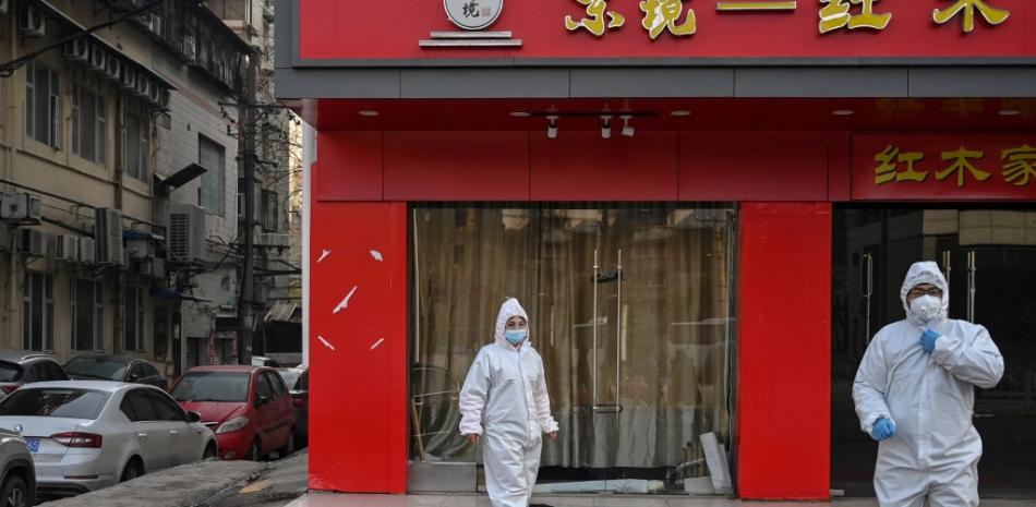 Tomada el 30 de enero de 2020 muestra a funcionarios con trajes protectores controlando a un anciano con una mascarilla que se derrumbó y murió en una calle cerca de un hospital en Wuhan.

Foto: HECTOR RETAMAL / AFP