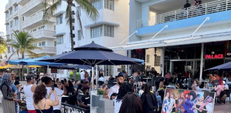 Clientes se paran afuera de un bar abarrotado y toman fotografías de un espectáculo de drag queens mientras esperan ingresar a South Beach en medio de la pandemia de Coronavirus. Foto: Daniel Slim/AFP.