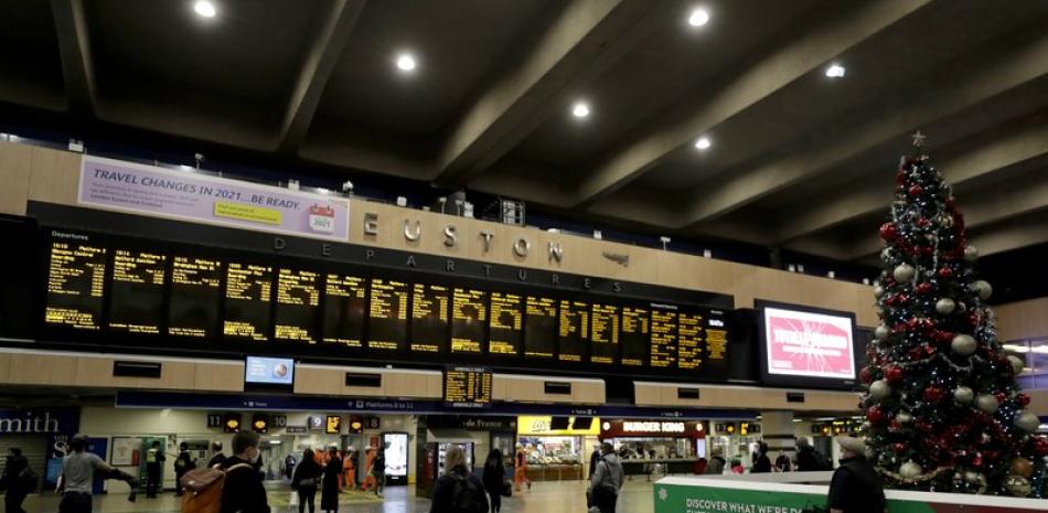 Varias personas aguardan para abordar trenes el viernes 18 de diciembre de 2020 en la estación Euston, en Londres. (AP Foto/Matt Dunham)