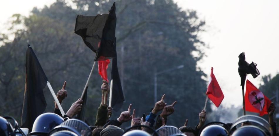 Estudiantes nepalíes afiliados a la Unión de Estudiantes de Nepal corean en contra del primer ministro Khadga Prasad Oli durante una protesta en Katmandú, Nepal, el domingo 20 de diciembre de 2020. (AP Foto/Niranjan Shrestha)