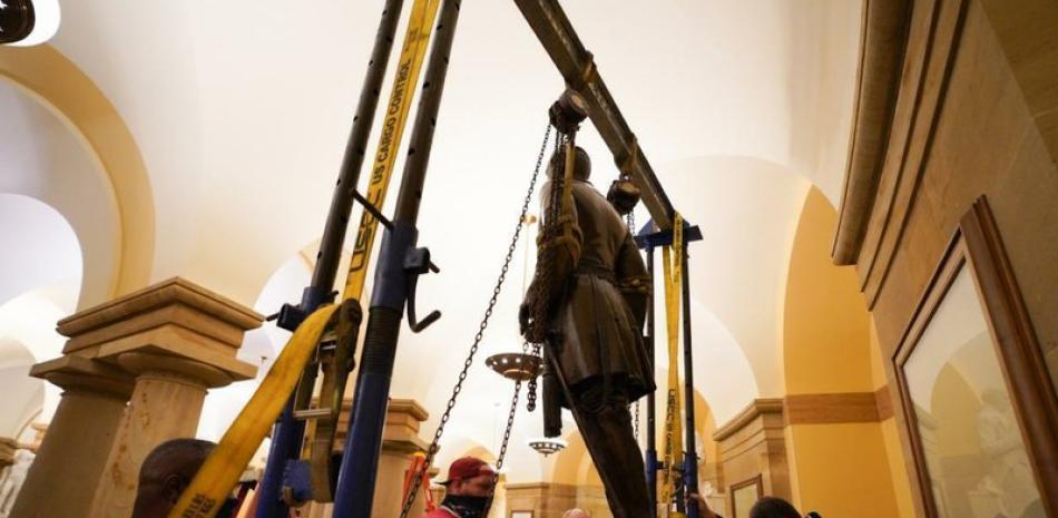 Unos trabajadores retiran la estatua del general confederado Robert E. Lee de la Sala Nacional de Estatuas del Capitolio, en Washington, el lunes 21 de diciembre de 2020. (Jack Mayer/Office of Governor of Virginia, Archivo)