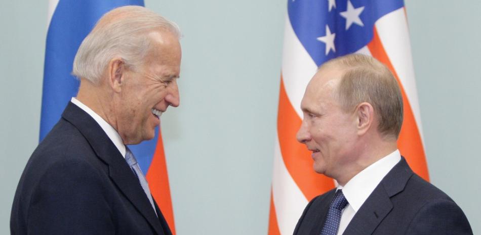 Foto de archivo tomada el 10 de marzo de 2011, el primer ministro ruso, Vladimir Putin, le da la mano al entonces vicepresidente de Estados Unidos, Joe Biden, durante su reunión en Moscú. ALEXEY DRUZHININ / PISCINA / AFP