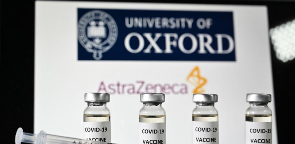 En esta foto de archivo tomada el 17 de noviembre de 2020 Una imagen ilustrativa muestra frascos con adhesivos de vacuna Covid-19 adheridos y jeringas, con el logotipo de la Universidad de Oxford y su empresa farmacéutica británica asociada AstraZeneca. JUSTIN TALLIS / AFP