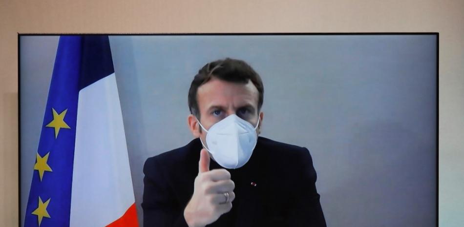 Presidente francés Emmanuel Macron, que dio positivo por la enfermedad del coronavirus (COVID-19), se ve en una pantalla mientras asiste por videoconferencia a una mesa redonda para la Conferencia Nacional Humanitaria ( NHC) en el Ministerio de Relaciones Exteriores de París. Charles Platiau / PISCINA / AFP
