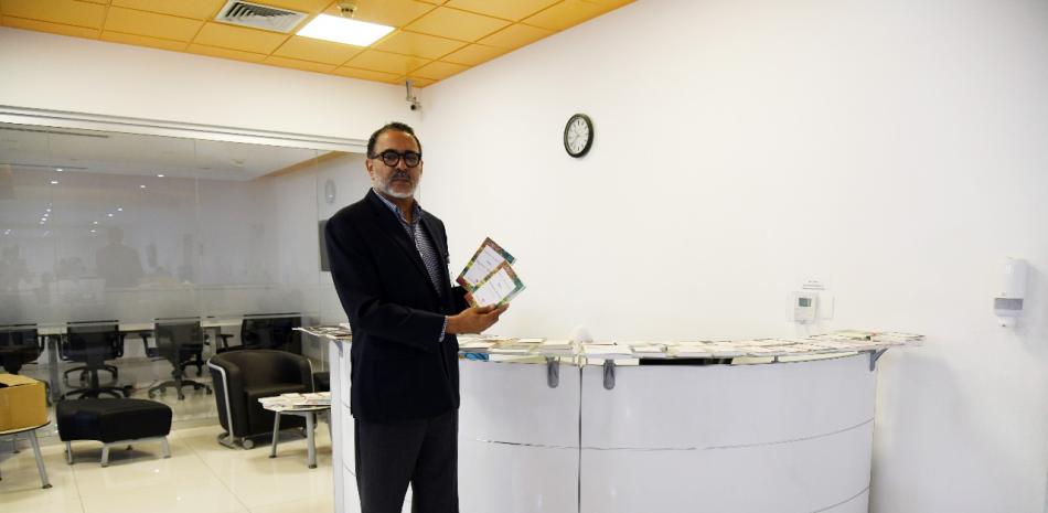 El director general de cultura del Ministerio de Educación, Luis R. Santos, entrega una colección de libros de autores dominicanos para ser distribuidos entre el personal de Listín Diario.