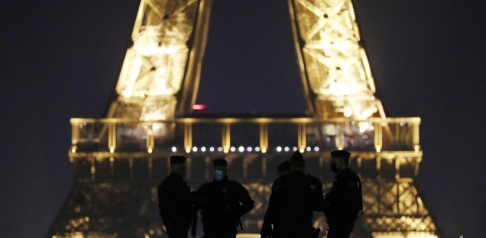 Policías patrullan la plaza Trocadero cerca de la Torre Eiffel en la víspera del Año Nuevo, el 31 de diciembre de 2020, en París, Francia. (AP Foto/Thibault Camus)
