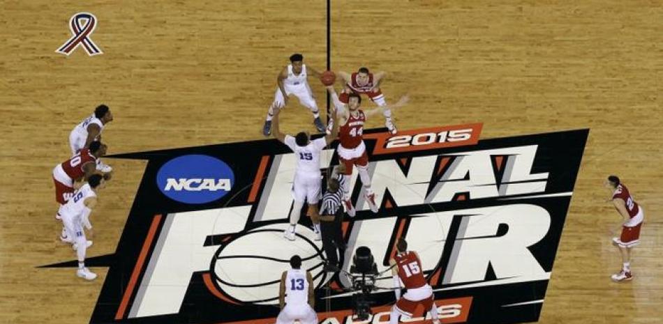 Jahlil Okafor (15) de Duke y Frank Kaminsky (44) de Wisconsin disputan el balón al dar inicio el partido por el campeonato universitario de baloncesto de la NCAA en Indianápolis, el lunes 4 de abril de 2015.