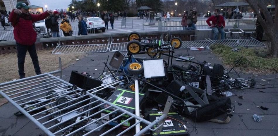 Manifestantes dejan una pila de equipos de televisión destrozados en el exterior del Capitolio de Estados Unidos, el 6 de enero de 2021, en Washington. (AP Foto/José Luis Magana)