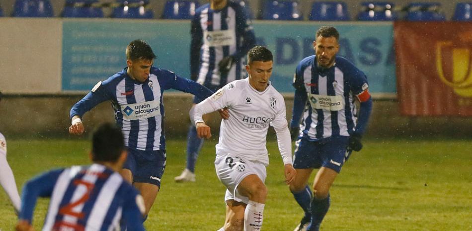 Jony Ñíguez maneja el balón ante la defensa de tres jugadores del Huesca. EFE