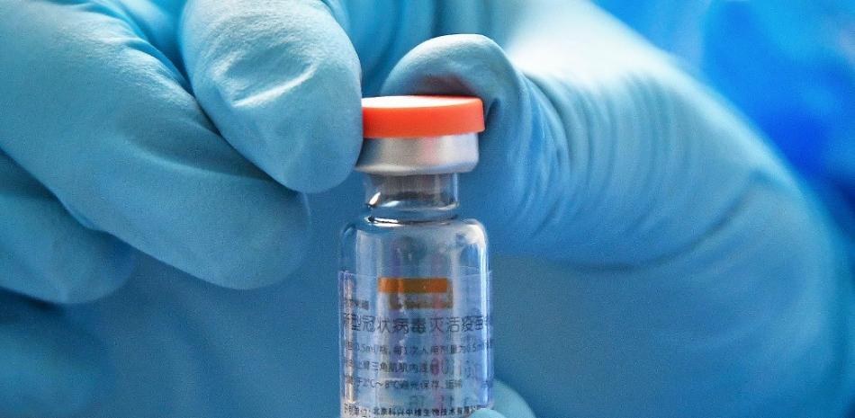 Un trabajador médico muestra un vial de la vacuna Sinovac Biotech contra el coronavirus COVID-19 en un centro de salud en Yantai, en la provincia de Shandong, en el este de China. Foto: STR/AFP.