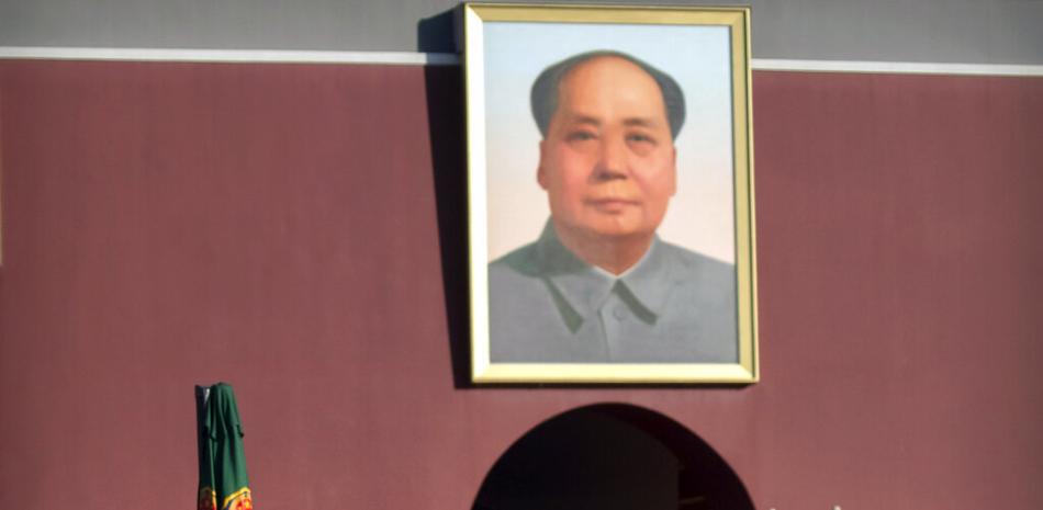 Agentes de la policía paramilitar china, con mascarilla para protegerse del coronavirus, hacer guardia cerca de un retrato del fallecido líder chino Mao Zedong, en la Puerta de Tiananmen, cerca de la Plaza de Tiananmen, en Beijing, el 9 de enero de 2021. (AP Foto/Mark Schiefelbein)
