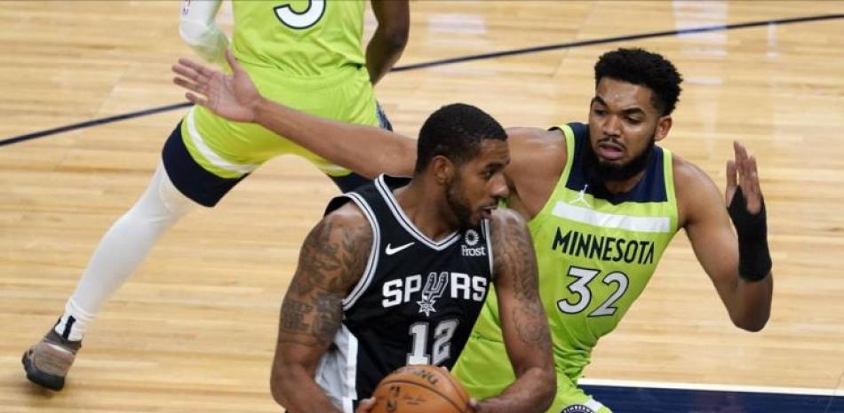 Karl-Anthony Towns, de Minnesota, defiende a LaMarcus Aldridge, de los Spurs, durante el partido del sábado en el baloncesto de la NBA.