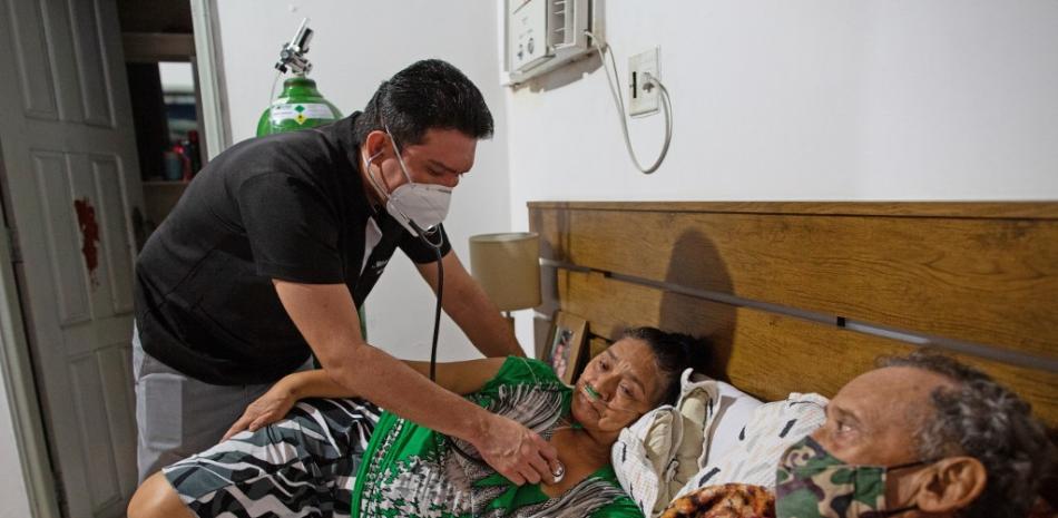 El médico brasileño de emergencias Marcos Fonseca Barbosa (izq.) Atiende a su madre Ruth Fonesca, de 56 años, y a su padre Glauco Rego Lima, de 72, en su casa de Manaus, estado de Amazonas, Brasil, el 10 de enero de 2021.
MICHAEL DANTAS / AFP