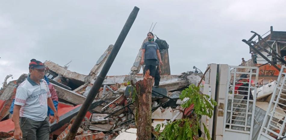 Residentes inspeccionan casas dañadas por un terremoto en Mamuju, Sulawesi Occidental, Indonesia, el 15 de enero de 2021. (AP Foto/Rudy Akdyaksyah)