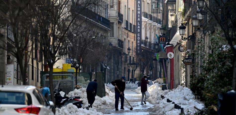 La gente limpia la nieve en una calle de Madrid después de que la tormenta Filomena trajo la nevada más fuerte en la región en 50 años