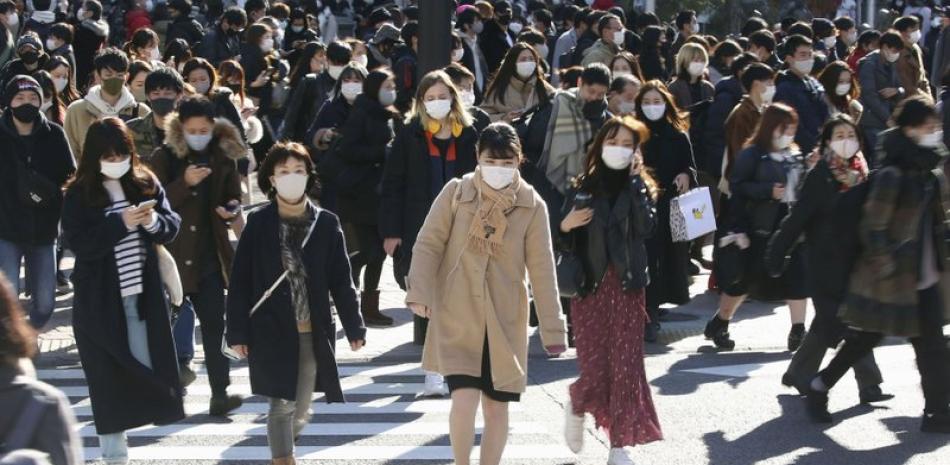 Una multitud con mascarillas para frenar la propagación del coronavirus se desplaza por una concurrida intersección en el distrito comercial de Shibuya, en Tokio, el sábado 26 de diciembre de 2020.

Foto: Kyodo News/ AP