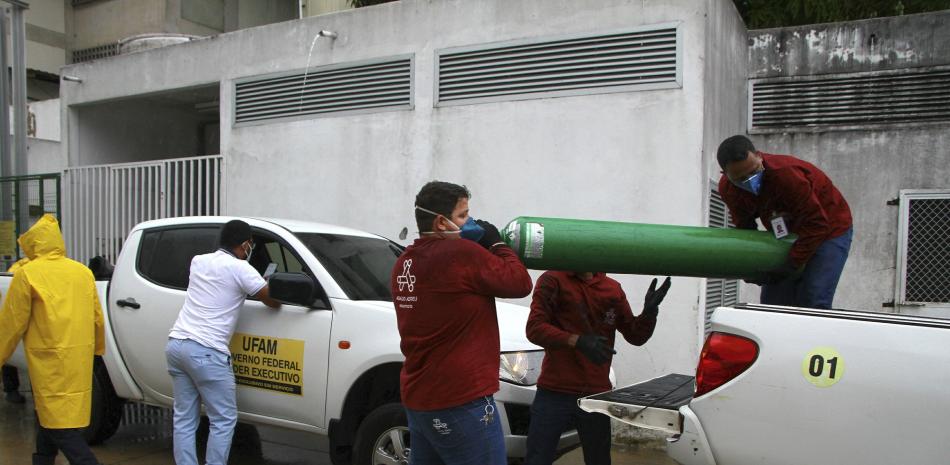 Trabajadores de la Universidad Federal de Amazonas cargan tanques de oxígeno vacíos el jueves 14 de enero de 2021 en el Hospital Getulio Vargas en medio de la pandemia de coronavirus, en Manaos, Brasil.

Foto: AP/ Edmar Barros