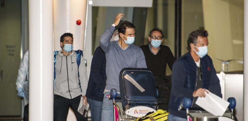 El tenista español Rafael Nadal, centro, llega al Aeropuerto Adelaide antes de someterse a un periodo de cuarentena previo al Abierto de Australia, en Adelaide, Australia.