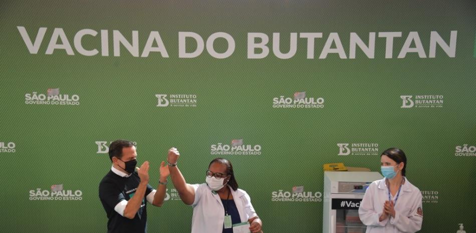 Nurse Mónica Calazansis reacciona junto al gobernador de Sao Paulo Joao Doria, luego de ser inoculada con la vacuna CoronaVac Sinovac Biotech  en el hospital de Clínicas en Sao Paulo, Brasil.

 Foto: NELSON ALMEIDA