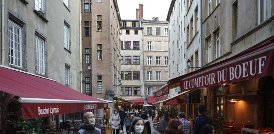 Personas con mascarilla para protegerse del coronavirus pasan frente a restaurantes el sábado 10 de octubre de 2020 en el centro de Lyon, Francia.

Foto: AP/ Laurent Cipriani