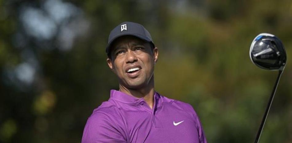 Tiger Woods mirando su golpe de salida en el primer hoyo durante la primera ronda del campeonato de golf de la PNC, en Orlando, Florida. Woods anunció el martes 19 de enero de 2021 que había una quinta cirugía de espalda y se perderá torneos en San Diego y Los Ángeles.