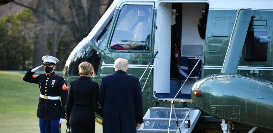 El presidente de Estados Unidos, Donald Trump, y la primera dama Melania se dirigen a abordar el Marine One antes de partir desde el jardín sur de la Casa Blanca en Washington, DC el 20 de enero de 2021. MANDEL NGAN / AFP