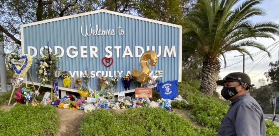 En esta foto del 13 de enero de 2021, un seguidor de los Dodgers de Los Ángeles monta guardia ante un altar erigido en memoria de Tommy Lasorda, manager de los Dodgers de Los Ángeles, quien falleció la semana anterior.