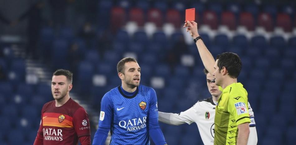 El árbitro Davide Ghersini, derecha, muestra la tarjeta roja al portero español Pau López, centro, de la Roma, en duelo por los octavos de final de la Copa de Italia ante el Spezia, en el Estadio Olímpico de Roma, el martes 19 de enero de 2021.