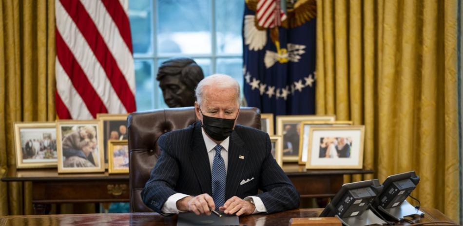 El presidente de los Estados Unidos, Joe Biden, se prepara para firmar una orden ejecutiva en la Oficina Oval de la Casa Blanca el 25 de enero de 2021 en Washington, DC. El presidente Biden firmó una orden ejecutiva que deroga la prohibición de que las personas transgénero sirvan abiertamente en el ejército. Doug Mills-Pool / Getty Images / AFP