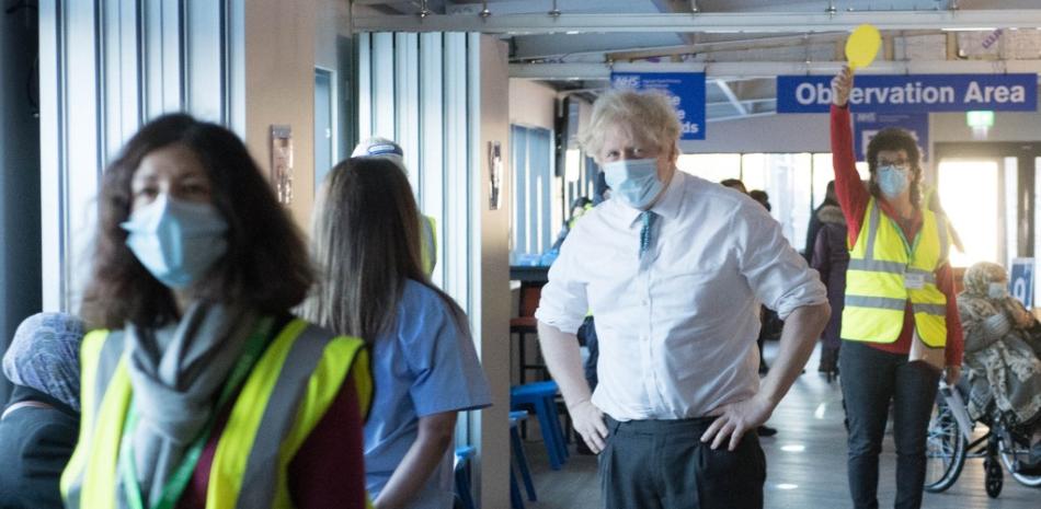El primer ministro Boris Johnson se reúne con el personal durante una visita al terreno de Barnet FC en The Hive, al norte de Londres, que se utilizará como centro de vacunación contra el coronavirus el 25 de enero de 2021.
Stefan Rousseau / PISCINA / AFP