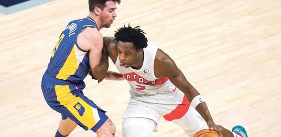 OG Anunoby, de Toronto, avanza con el balón hacia la canasta mientras lo defiende T.J. McConnell, de Indiana, en el partido del domingo en el baloncesto de la NBA.