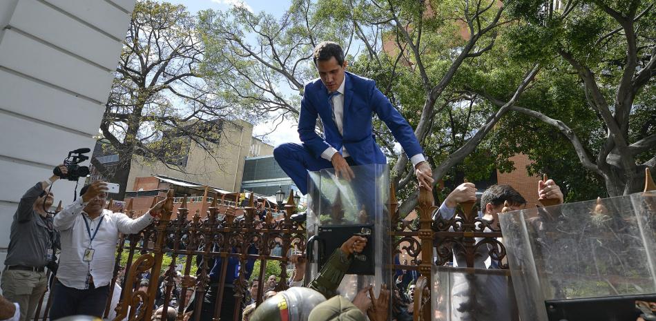 Juan Guaidó, presidente de la Asamblea Nacional saliente de Venezuela y líder opositor, trepa la cerca en un inyento fallido para ingresar al complejo de la legislatura el 5 de enero del 2020, cuando él y legisladores opositores se vieron impedidos de entrar.

Foto: AP/Matías Delacroix