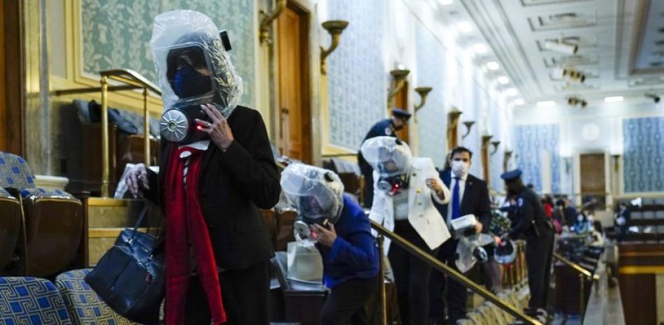 La gente se refugia en la galería de la Cámara mientras los manifestantes intentan irrumpir en la Cámara de la Cámara en el Capitolio de los Estados Unidos el miércoles 6 de enero de 2021 en Washington.

Foto: AP/ Andrew Harnik