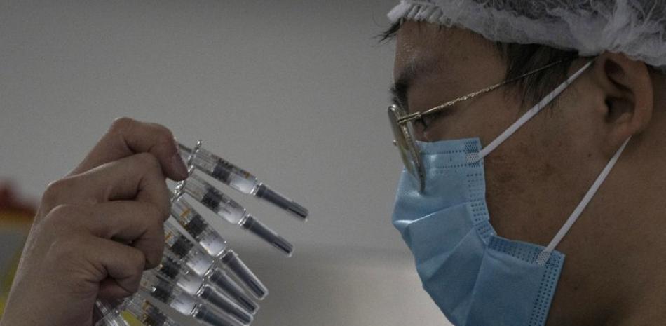 Un trabajador revisa jeringuillas con una vacuna contra el COVID-19 producida por Sinovac en su fábrica de Beijing, el jueves 24 de septiembre de 2020.

Foto: AP/ Ng Han Guan
