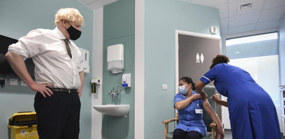 En esta fotografía de archivo del 4 de enero de 2021, el primer ministro británico Boris Johnson observa a la enfermera Jennifer Dumasi ser inyectada con la vacuna de Oxford-AstraZeneca contra el COVID-19, en el Hospital Chase Farm del norte de Londres.

Foto: Stefan Rousseau /Pool / AP