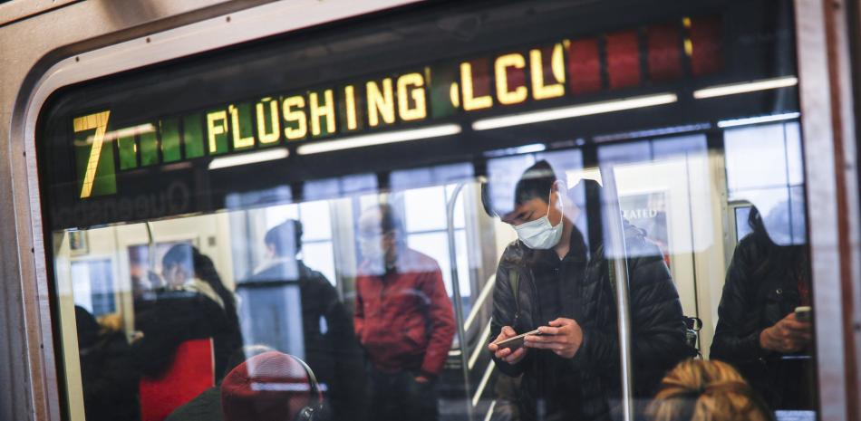 En imagen de archivo del 7 de abril de 2020, algunas personas portan mascarillas mientras viajan en el sistema de metro de la ciudad de Nueva York durante la pandemia del coronavirus, en Nueva York.

Foto: AP/ John Minchillo
