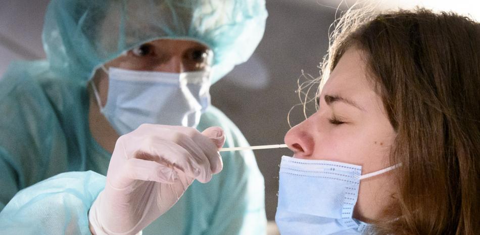 Un trabajador de salud recoge una muestra para una prueba de reacción en cadena de la polimerasa el martes 3 de noviembre de 2020 en una instalación en Cernier, Suiza, en medio de la pandemia de coronavirus.

Foto: AP/ KEYSTONE/ Laurent Gillieron)